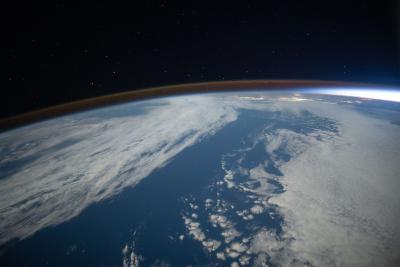 The airglow blankets the Earth's horizon during an orbital sunset in this photograph from the International Space Station as it orbited 262 miles above the Pacific Ocean southwest of California.