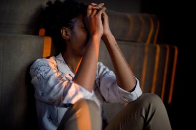 A woman sitting with her hands covering face to represent depression