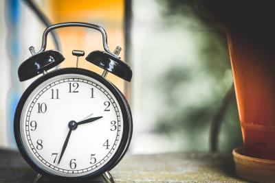 Photo of a round, black clock with alarm bells on top. 