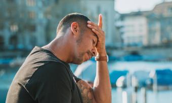 A man holding his head because his head hurts. 