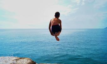 Child jumping off into ocean